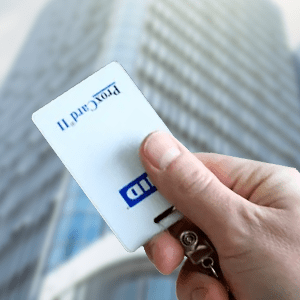 HID Global RFID Badge held by employee in front of skyscraper
